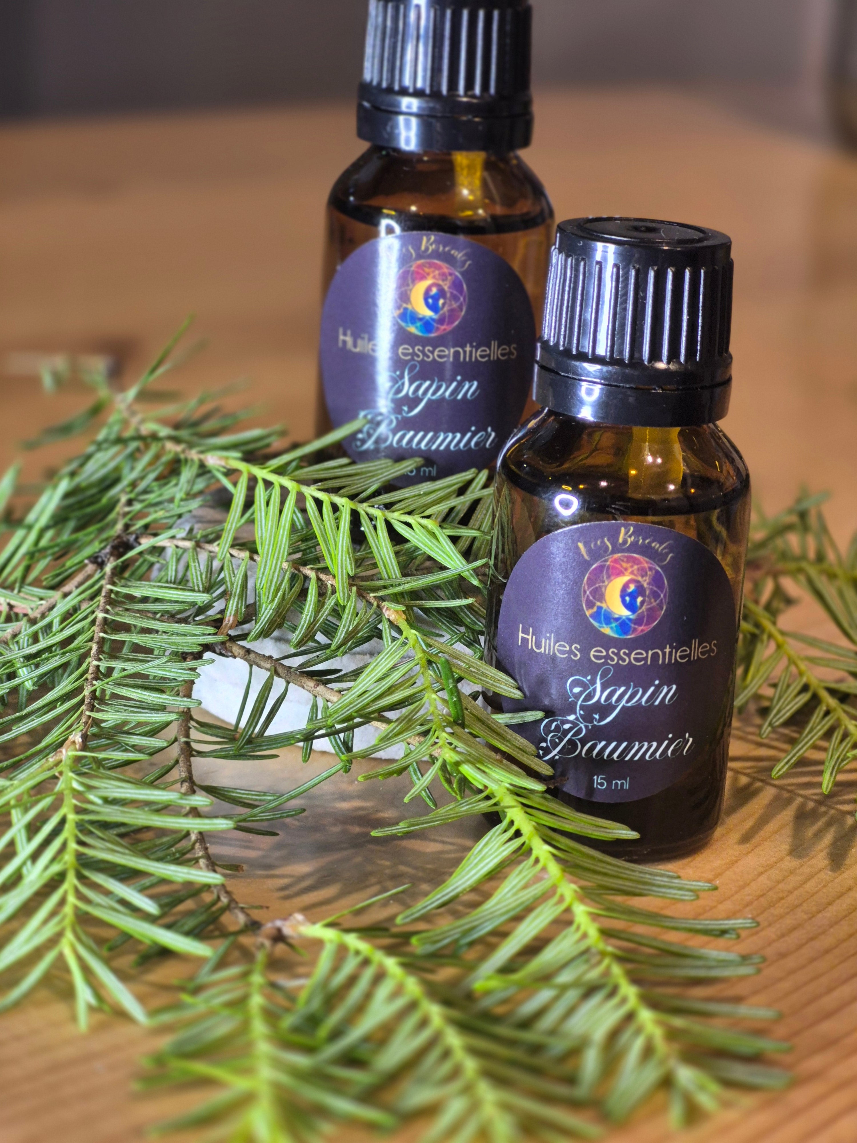 Huile essentielle de sapin baumier 15 ml – Fées Boréales, flacon ambré avec étiquette mauve et or, entouré de branches de sapin