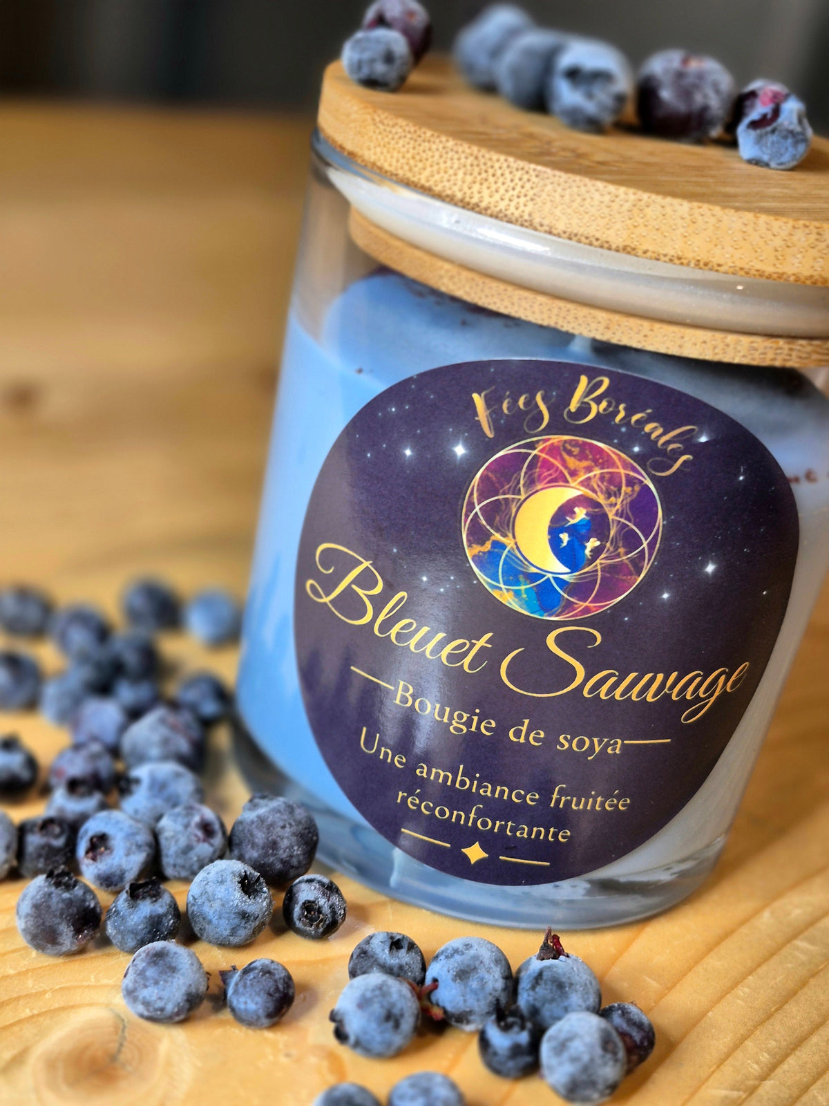 Bougie de soya Bleuet Sauvage – Fées Boréales, pot en verre avec couvercle en bambou, entouré de bleuets sauvages